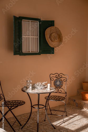 italian patio with vintage table near green wooden window at sunset. italian decoration, free space