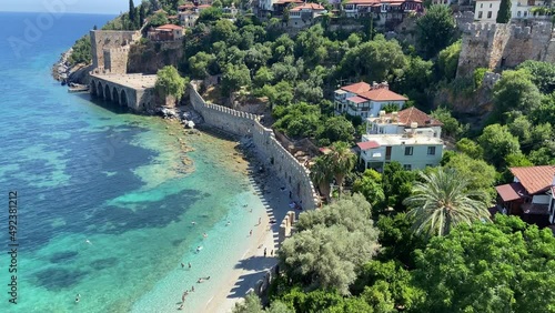 Beautiful sunny Alanya beach, blue warm water, sweaming peoples, old castle wall