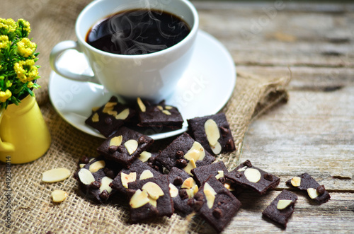 Cup of coffee and tasty cookies on wooden background. Tea time and breakfast concept.