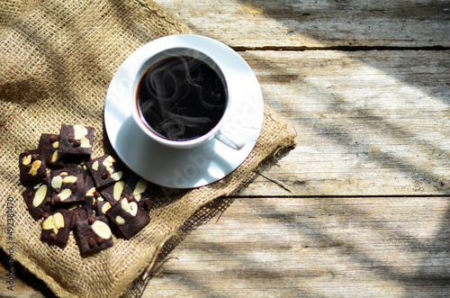 Cup of coffee and tasty cookies on wooden background. Tea time and breakfast concept.