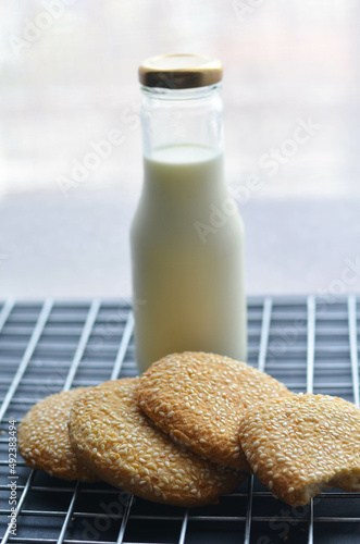 A bottle of milk and low calories sesame biscuits : healthy lifestyle concept (selective focus image)