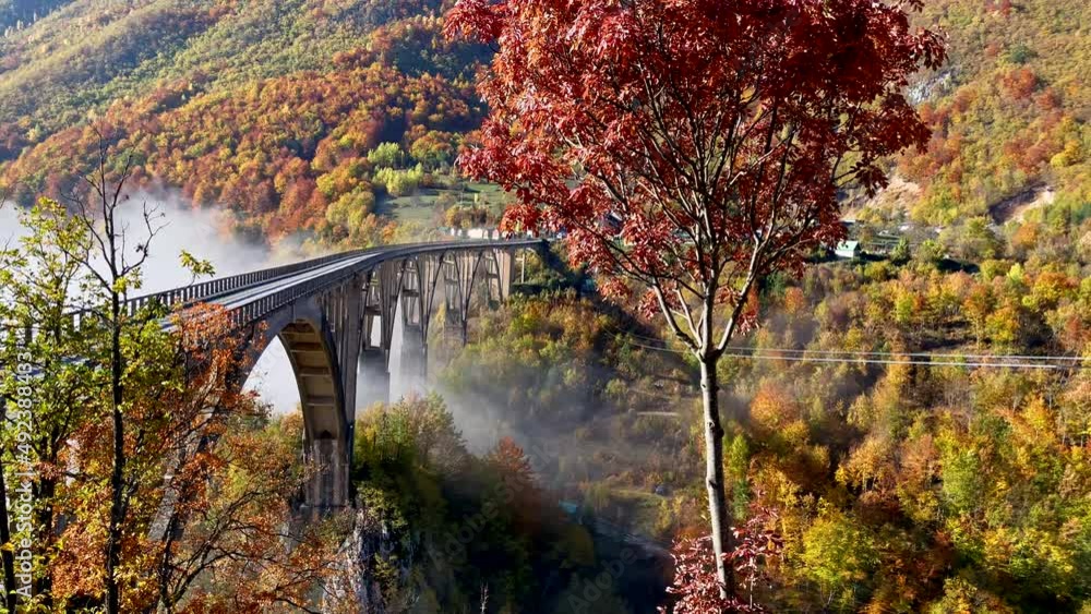 A handheld shot of the magnificent Djurdjevica Bridge over the Tara river canyon in the northern part of Montenegro. Shot in the fall season. Travel to Eastern Europe concept A handheld shot of the magnificent Djurdjevica Bridge over the Tara river canyon in the northern part of Montenegro. Shot in the fall season. Travel to Eastern Europe concept