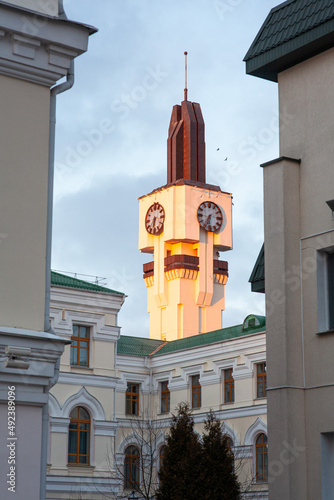 the clock tower lit by the sun rises above the ancient building