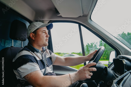 young male truck driver on a rides behind the wheel