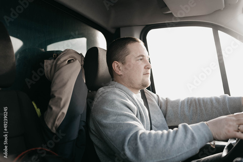 a male truck driver is driving, a young european man. © velimir