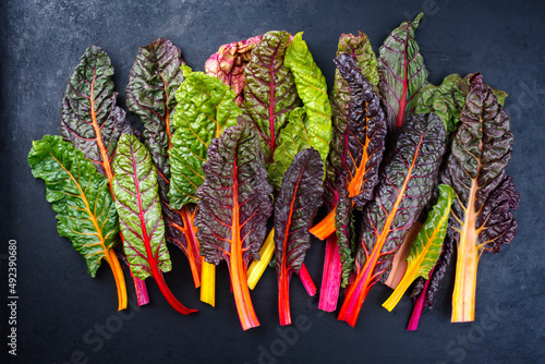 Quadro em tela Raw colourful chard offered as a close-up on a rustic black board