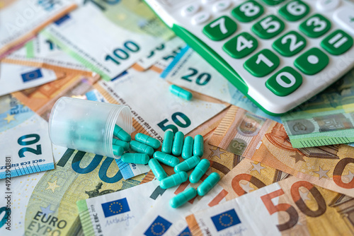 different pills calculator and euro banknotes. medical concept