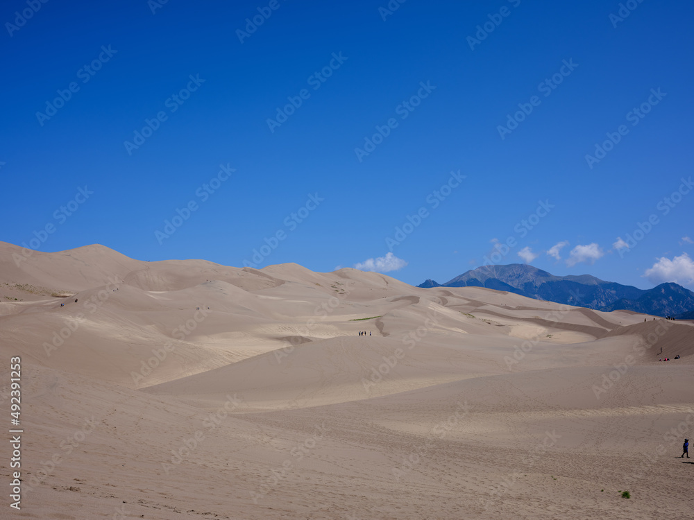 The Great Sand dunes in Colorado on a perfect afternoon with a small group of people on the dunes for scale