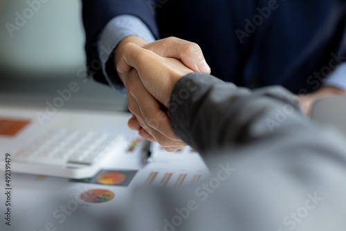 Close-up two business men holding hands, Two businessmen are agreeing on business together and shaking hands after a successful negotiation. Handshaking is a Western greeting or congratulation. photo