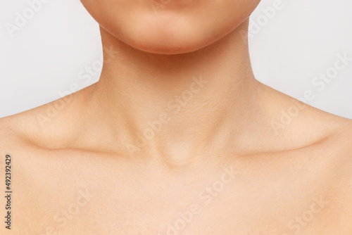 Cropped shot of a young woman's collarbone isolated on a white background. Body care, cosmetology. Soft delicate skin.  Close-up photo