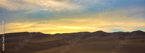 Panoramic image of large sand dunes at sunset and dusk on Colorado