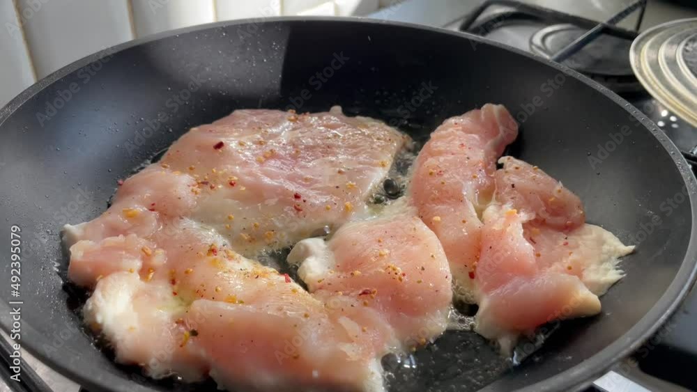 Cooking of chicken breasts in frying pan in burning oil. Cooking of chicken breasts in frying pan in burning oil.