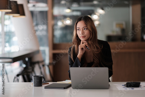 Obraz na plátně Asian beautiful woman thinking idea and working with laptop computer for financi