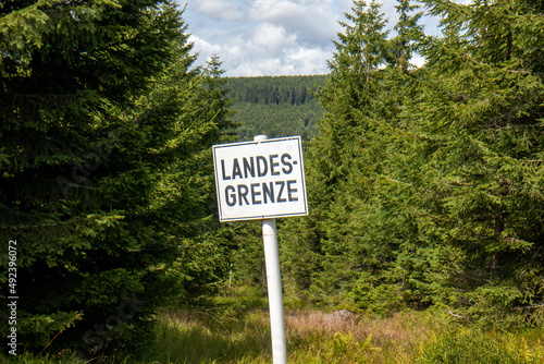 Boundary marker of the German border with the Czech Republic Boundary stone and sign that says Land border in German