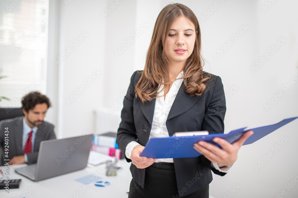 Businesswoman reading a document in her office Businesswoman reading a document in her office