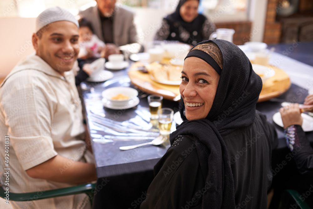 Breaking fast as a family. Portrait of a muslim woman looking back while enjoying a feast with her family. Breaking fast as a family. Portrait of a muslim woman looking back while enjoying a feast with her family.