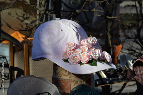 Sticker An overzized pink base cap with roses on a flea market in Berlin-City