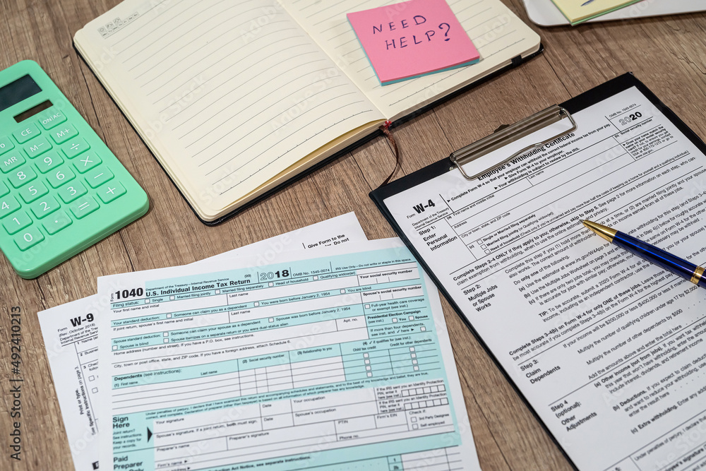 many us tax form 1040 w4 w9 on office desk. financial documents many us tax form 1040 w4 w9 on office desk. financial documents
