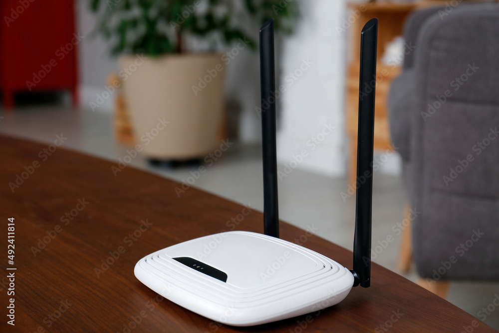 Modern Wi-Fi router on wooden table indoors. Space for text Modern Wi-Fi router on wooden table indoors. Space for text