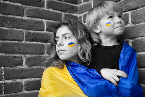 boy and young woman with Ukrainian flag. Color accent yellow and blue. Family, unity, support, national independence. Children of Ukraine against the war. ask for help from the world community.