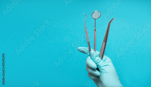 Set of medical dental equipment and dental floos in glove hand on blue background