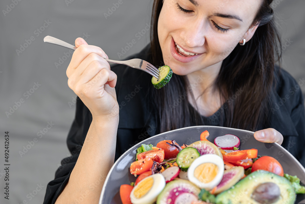 Appetizing salad with fresh vegetables and eggs in a plate in female hands. Appetizing salad with fresh vegetables and eggs in a plate in female hands.