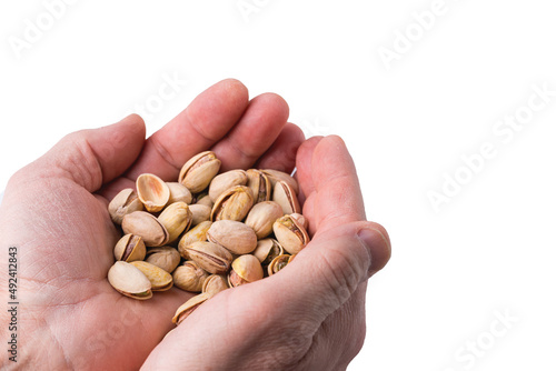 Close up view of person's hands holding handful of pistachios isolated on white background. Sweden.