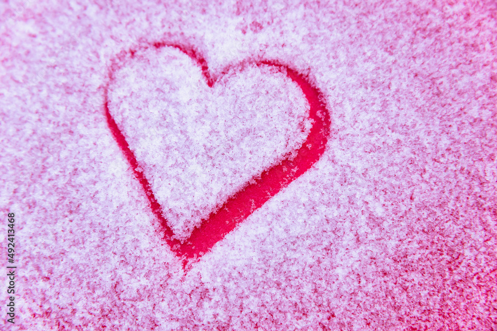 Heart on white snow and red background.