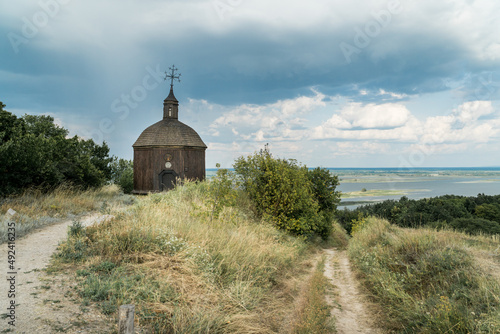 Landscape of a small wooden church on a hill with a magnificent view on a  Dneper river in Vitachov (Vytachov), Ukraine. photo