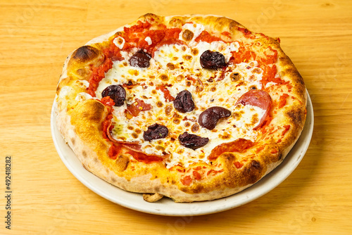 Pizza with salami, olives, and mozzarella 