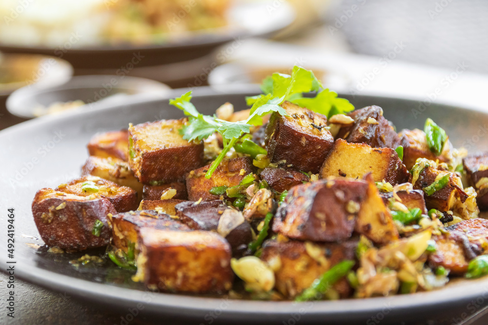 Stir-fried black tofu with chili, salt, garlic and pepper. Authentic the rare black tofu found only in Ratchaburi, Photharam Village, Thailand. Balance salty and sweet stew with sweet herbal gravy.