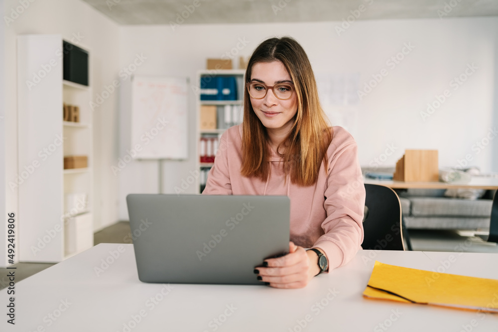 beautiful serious businesswoman. Sitting on chair working in a desk using laptop at the office beautiful serious businesswoman. Sitting on chair working in a desk using laptop at the office