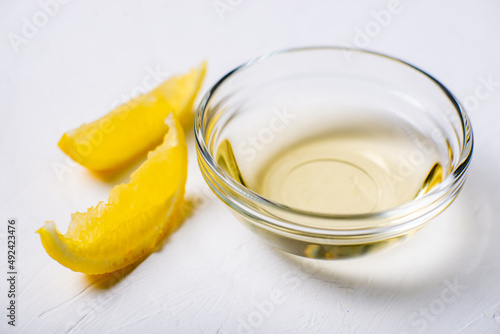 Lemon juice in a bowl. Essence. Lemon slices. White background.