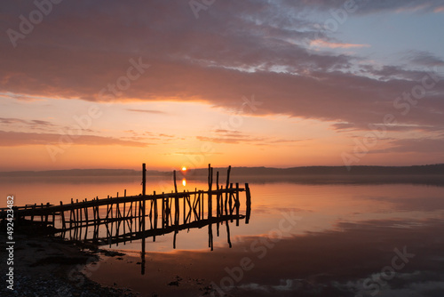 Scenic seascape with pier at sunset  burial at sea  condolences 