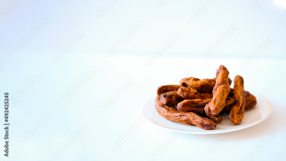 Obraz premium Dried bananas on a light plate. Copy space.