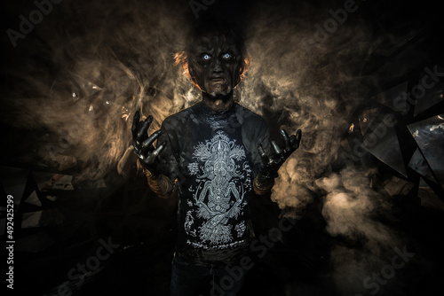 Foto scary sorcerer in smoke. voodoo rite