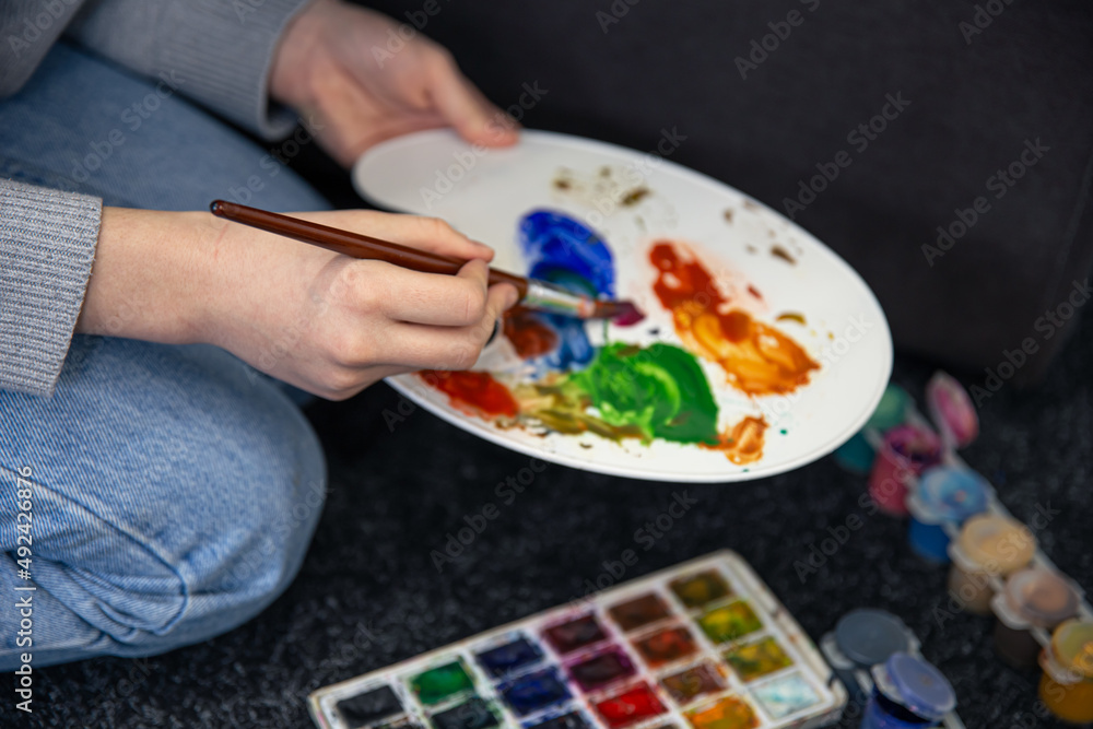 Close-up, paint on a palette in female hands. Close-up, paint on a palette in female hands.