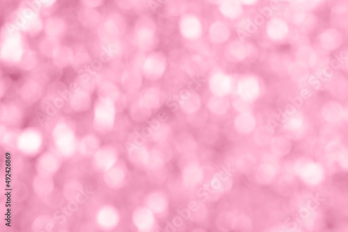 Abstract bokeh background. Light pink wallpaper. Bright blurred shimmering garland in soft focus. Trendy backplate for web design projects