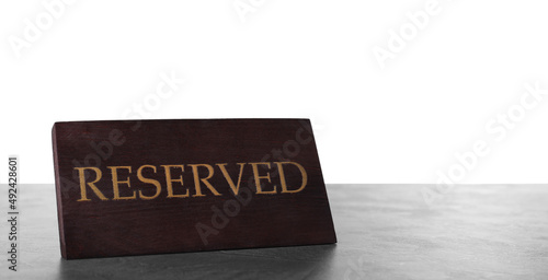 Elegant wooden sign Reserved on grey table against white background, space for text