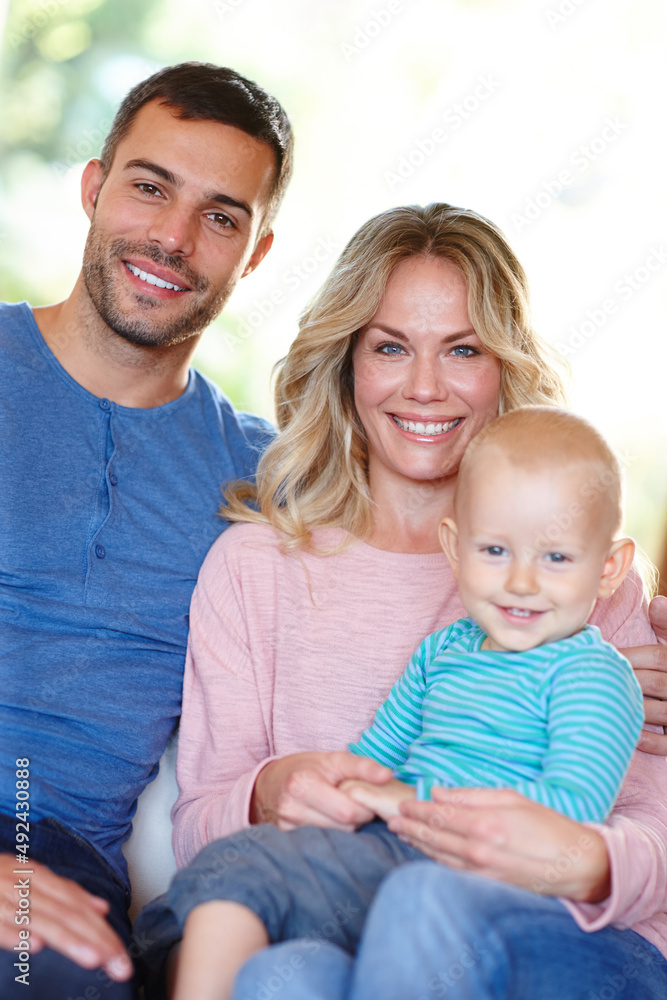 Hes our little bundle of joy. Portrait of a happy young family sitting at home.