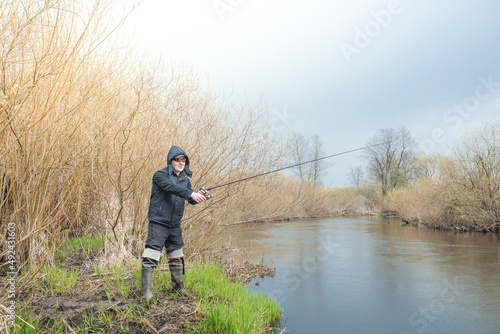 Fisherman pulls a fish with a spinning rod.
