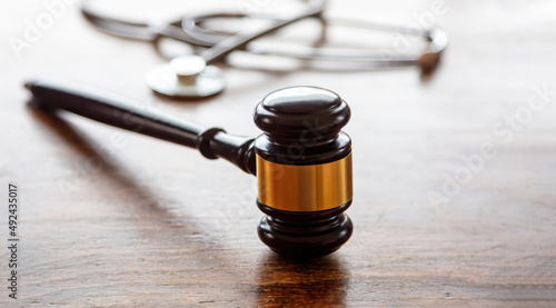 Healthcare Law. Medical stethoscope and judge gavel on lawyer office desk photo
