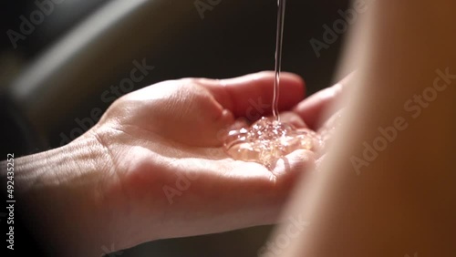 shampoo is poured into the hand. clear liquid photo