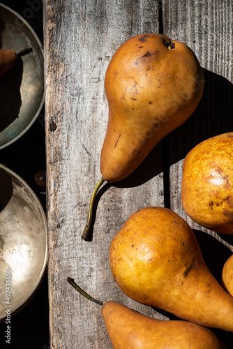 whole golden Bosc pears in still life on rustic vintage wooden crate photo