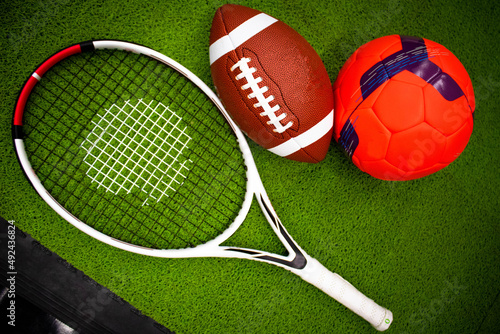objetos de deporte  raqueta de tenis  bal  n de Football  y bal  n pie  aislados en fondo verde