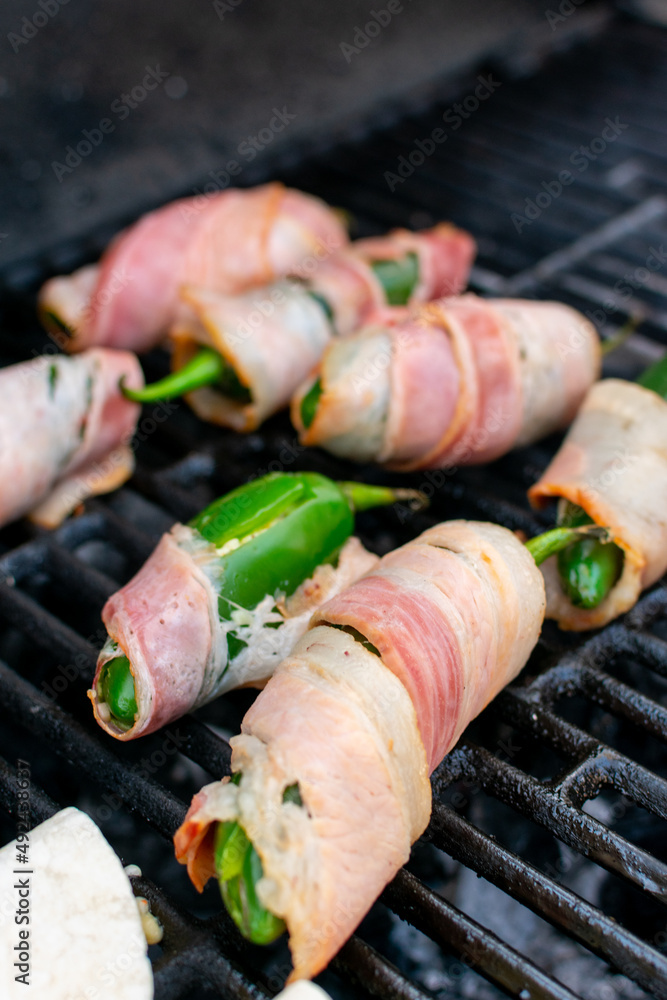 chiles jalapeños rellenos de queso y chorizo envueltos en tocino. chiles jalapeños manos preparando chiles jalapeños en el asador. chiles jalapeños rellenos de queso y chorizo envueltos en tocino. chiles jalapeños manos preparando chiles jalapeños en el asador.
