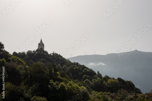 Typical landscape of Madeira Island. Chapel tower on high hill under cloudy sky. Sao Vicente village. Selective focus. 