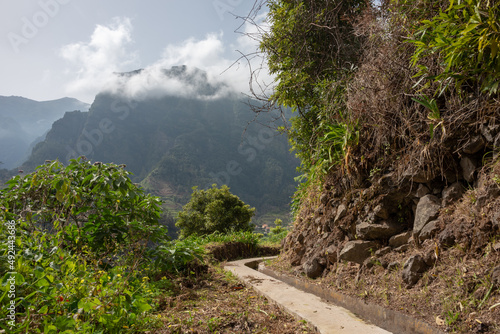 Levada hiking trail in Sao Vicente, north of Madeira Island. High mountains in the background. 