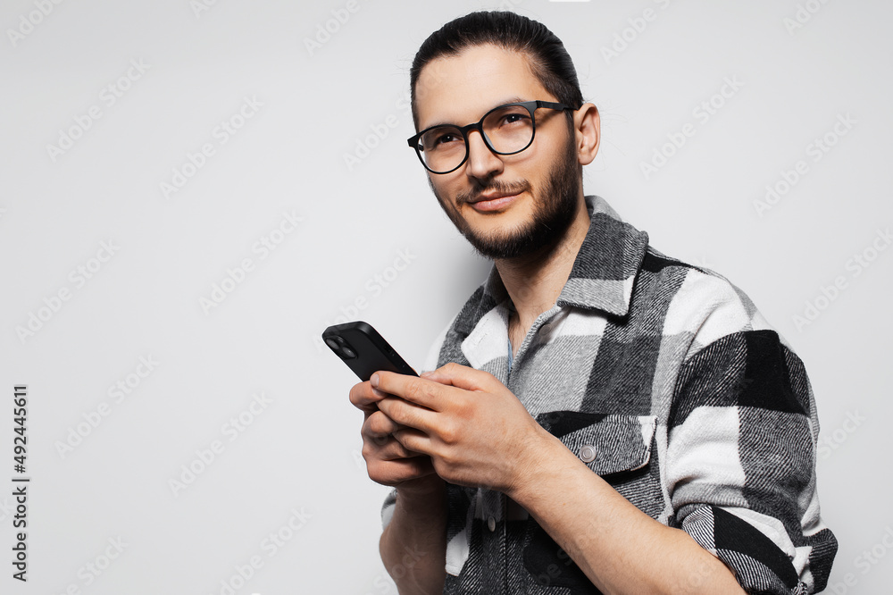 Young man using smartphone on grey studio background. Young man using smartphone on grey studio background.