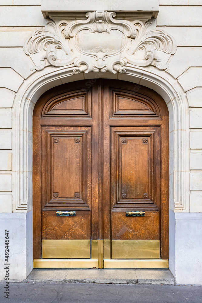 Paris, an ancient wooden door, beautiful facade in the 11e arrondissement
